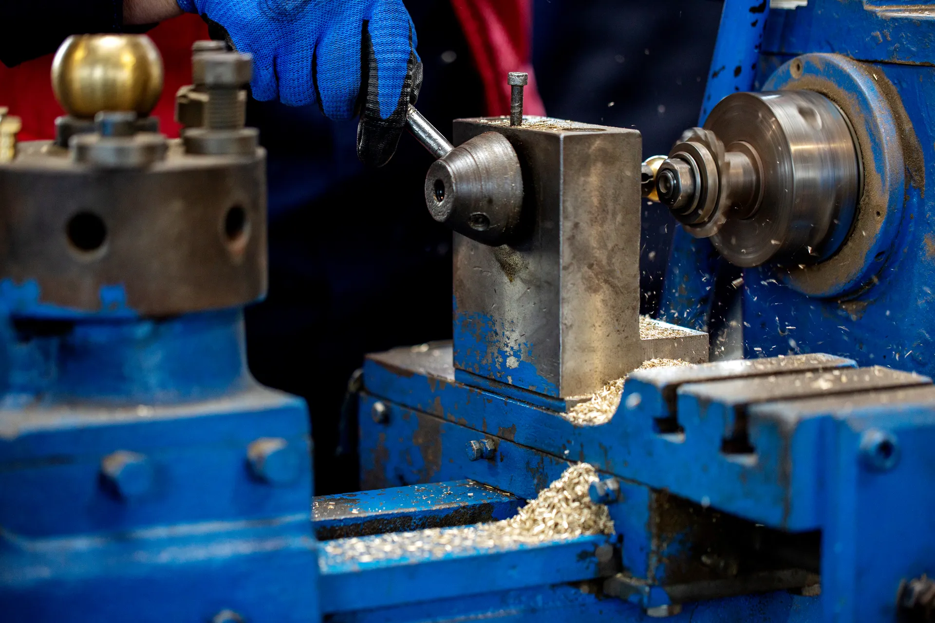 Operator turning brass components on an industrial lathe